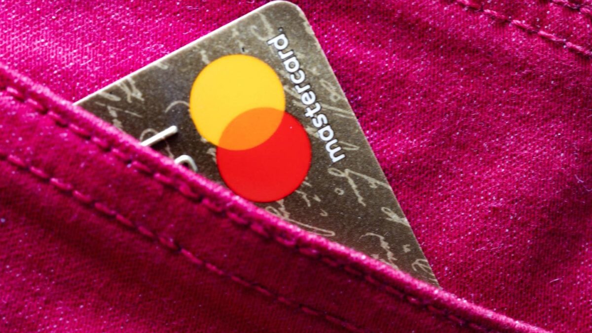 A Mastercard credit card peeking out from a pocket.