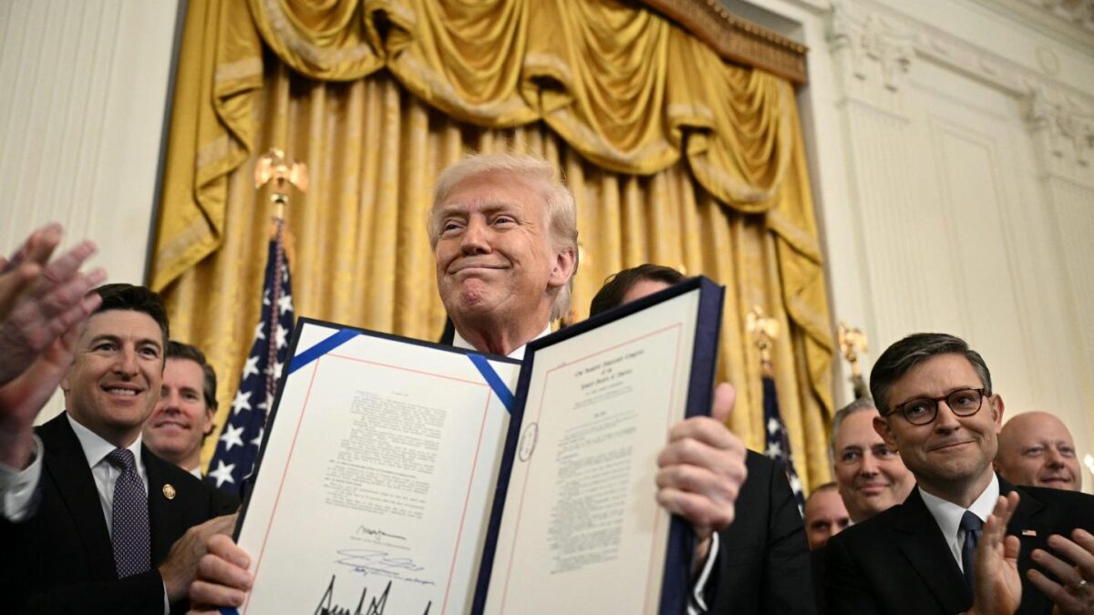 President Donald Trump displays the GENIUS Act (Guiding and Establishing National Innovation for U.S. Stablecoins Act), which codifies the use of stablecoins.