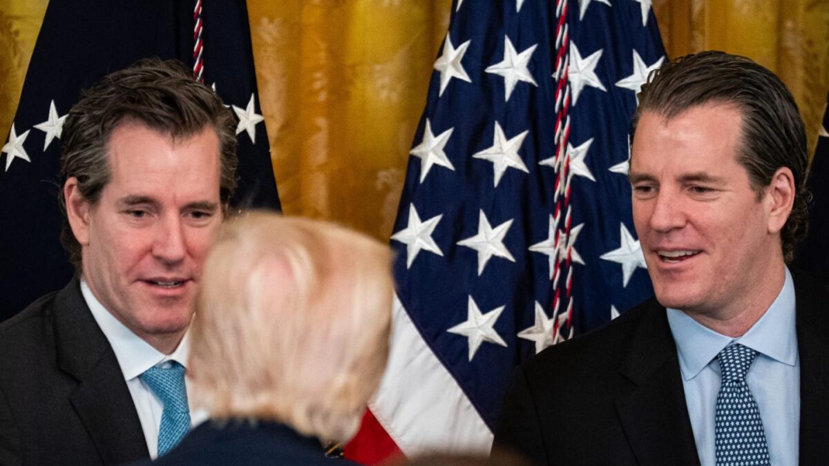 Cameron Winklevoss, co-founder and president of Gemini Trust Co., left, and Tyler Winklevoss, co-founder and chief executive officer of Gemini Trust Co., right, speak with US President Donald Trump during a signing ceremony for the GENIUS Act in the East Room of the White House in Washington, DC, US, on Friday, July 18, 2025.
