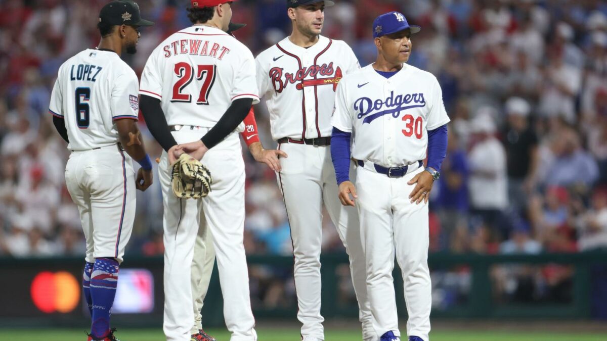 Four players from the LA Dodgers and Atlanta Braves stand together on the field during a baseball game.