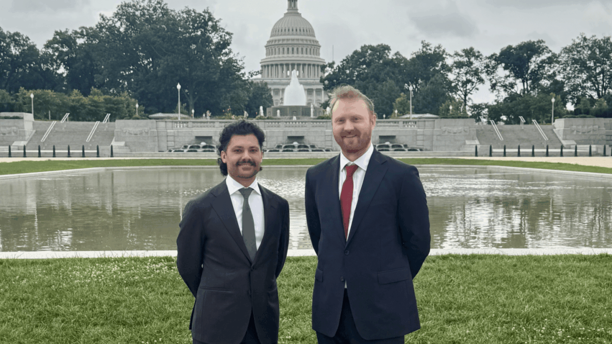 An image of Fabrizio Giabardo and Matt O'Connor in suits standing in front of the U.S. Capitol.