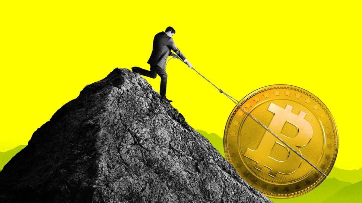 Man on mountain tries to pull bitcoin token uphill with rope.