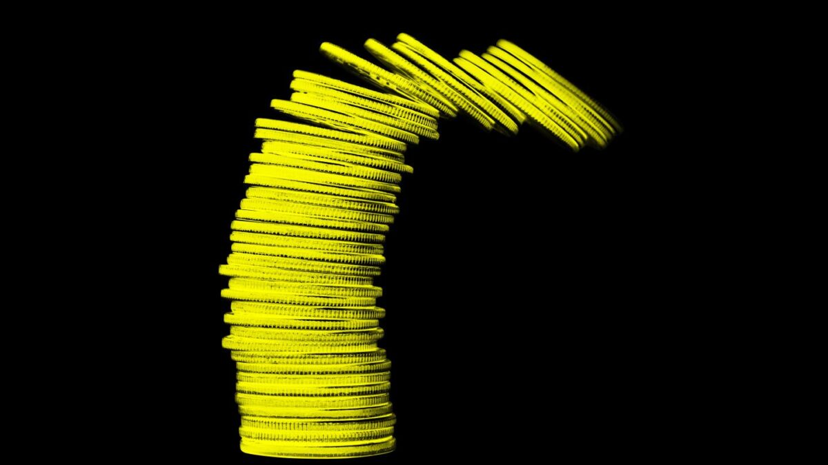 Stack of gold coins toppling over