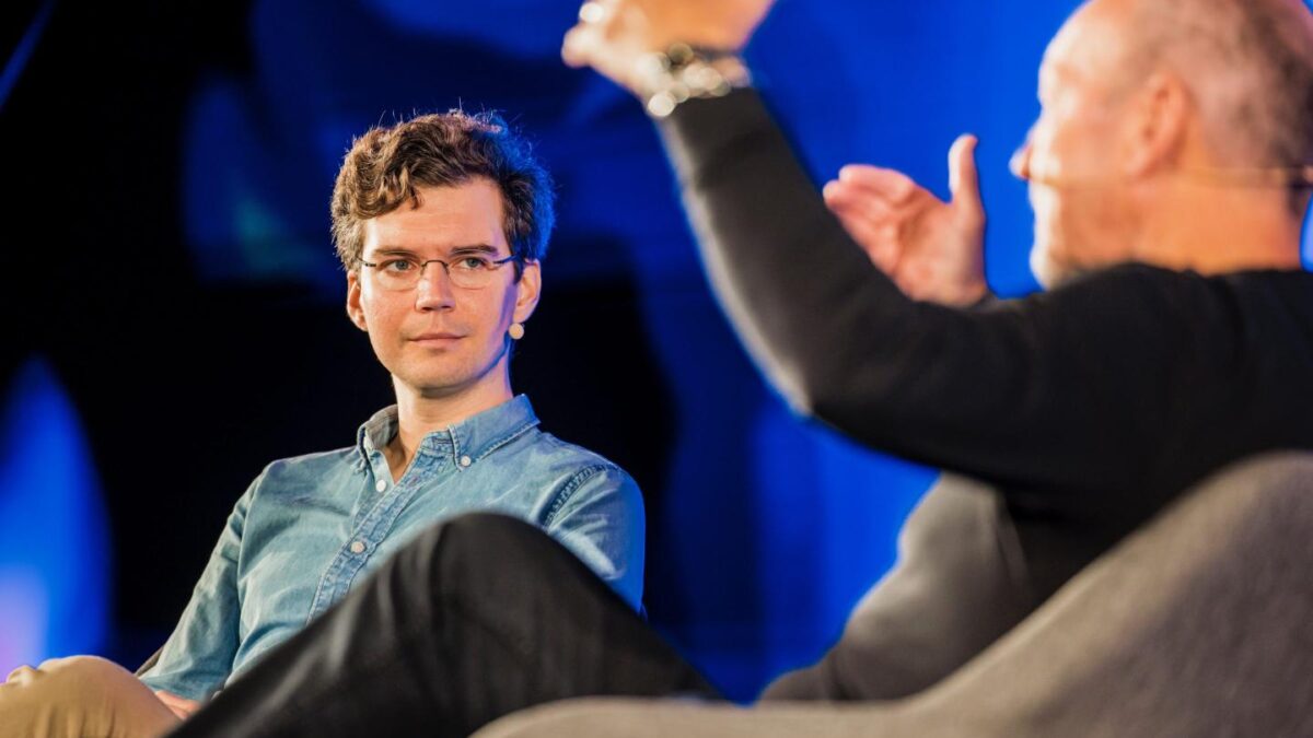 Austin Federa speaks on stage at a Solana conference.