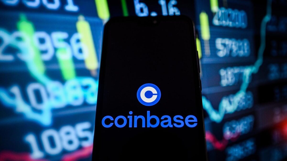 Coinbase logo displayed on a phone screen in front of a backdrop of numbers and graphs