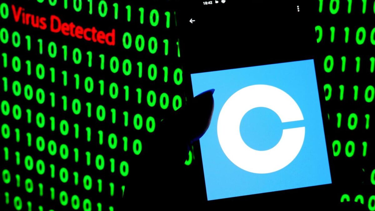 A Coinbase logo on a phone in front of a background of zeros and ones that says "Virus Detected"