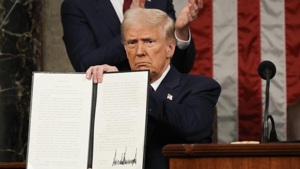 President Donald Trump shows an executive order he signed in March.