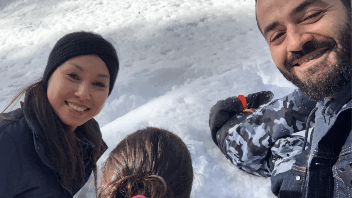 Photo of a woman, a child, and a man in a snowy landscape