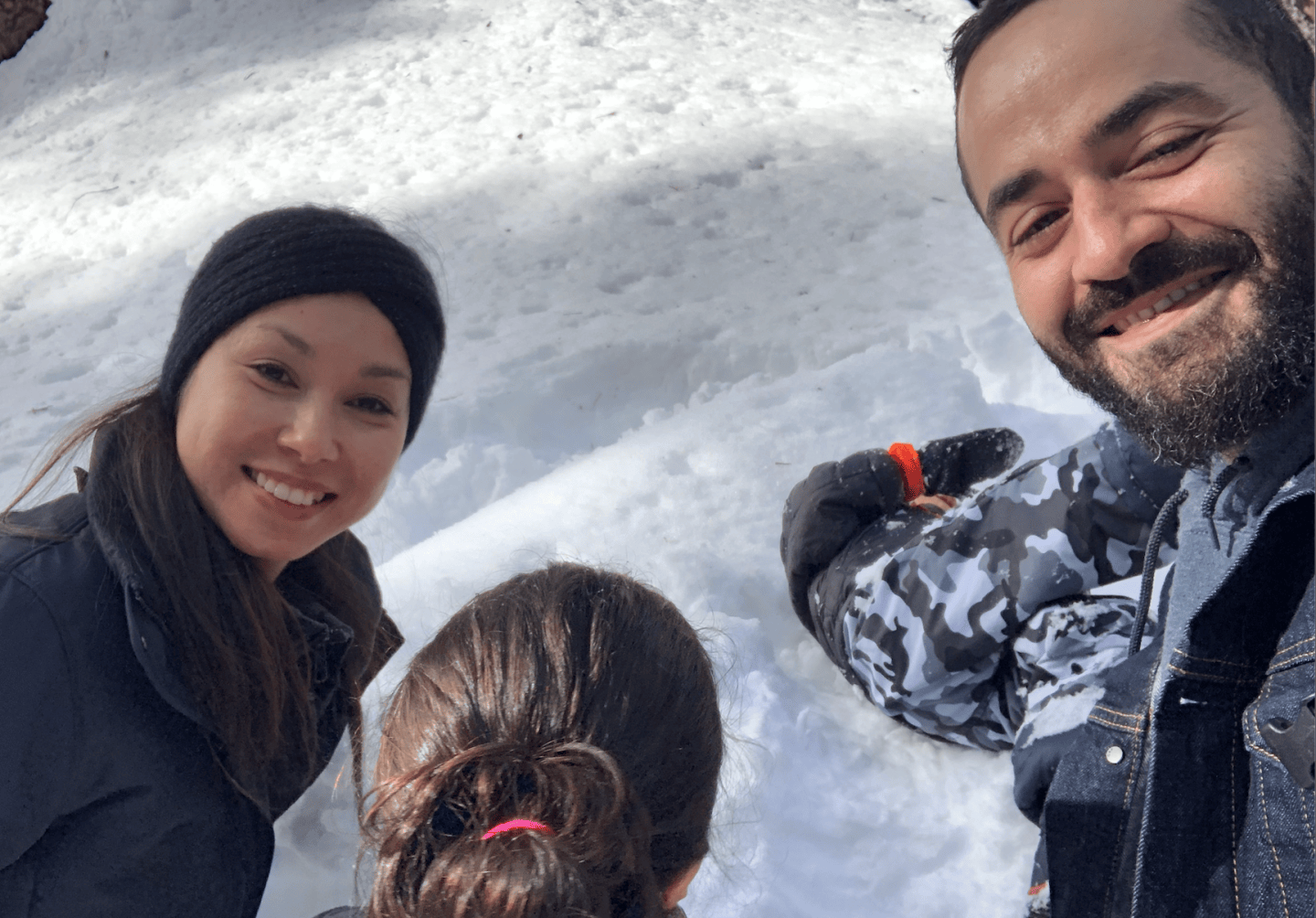 Photo of a woman, a child, and a man in a snowy landscape